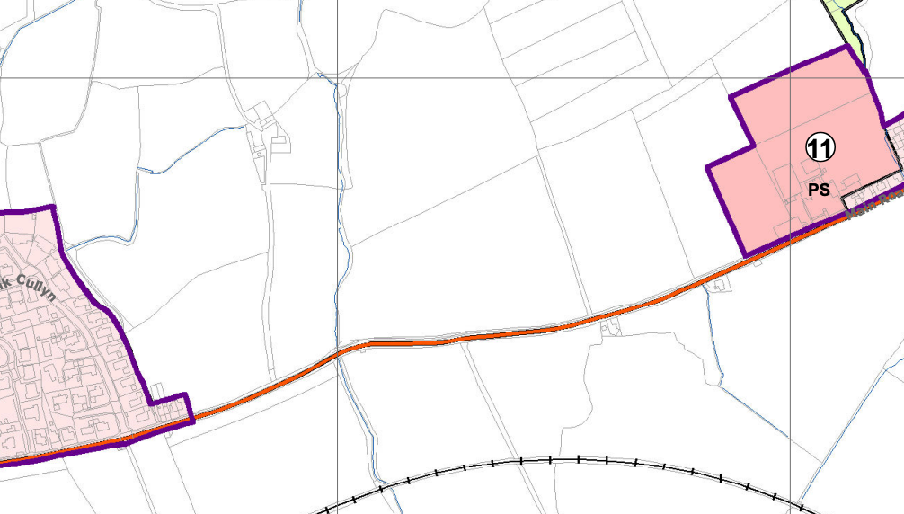 A planning map showing the application site highlighted in pink with a purple boundary, located near a road and a settlement.