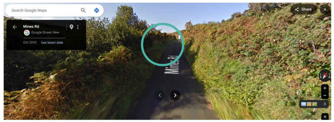 A Google Street View screenshot showing a narrow rural road named Mines Rd, with a teal circle highlighting a specific location further up the lane, likely indicating a field access point.