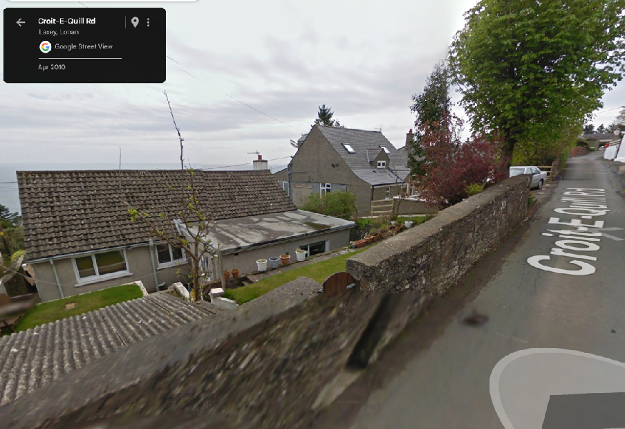 Google Street View screenshot showing a residential road with stone walls and houses in Lonan, dated April 2010.