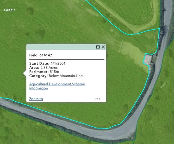 A screenshot of a GIS map interface showing a rural field with a blue boundary outline and a data pop-up window.