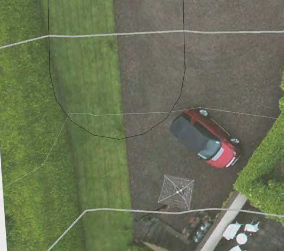 Aerial view of a rural property showing a driveway, lawn, and red car with white and black boundary lines overlaid.