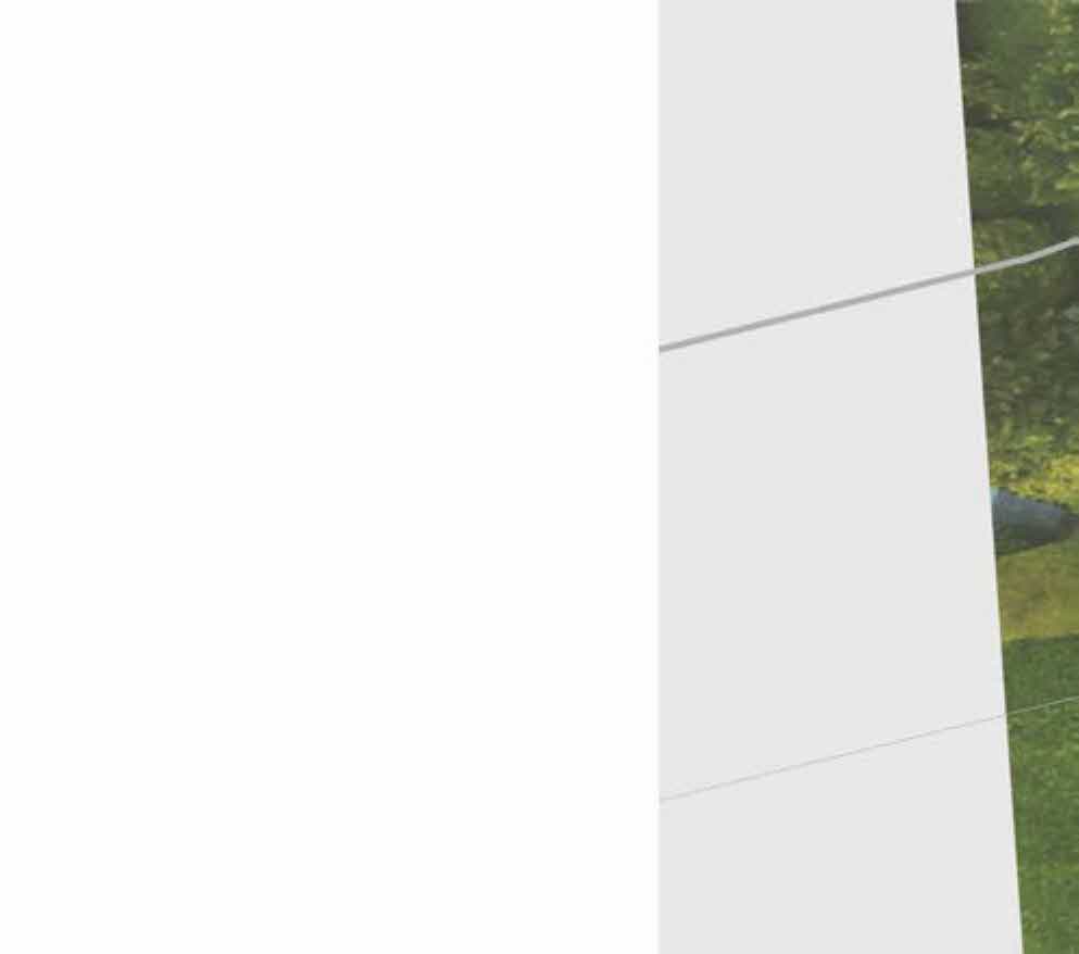 A cropped view showing a white vertical wall surface adjacent to green vegetation and grass.