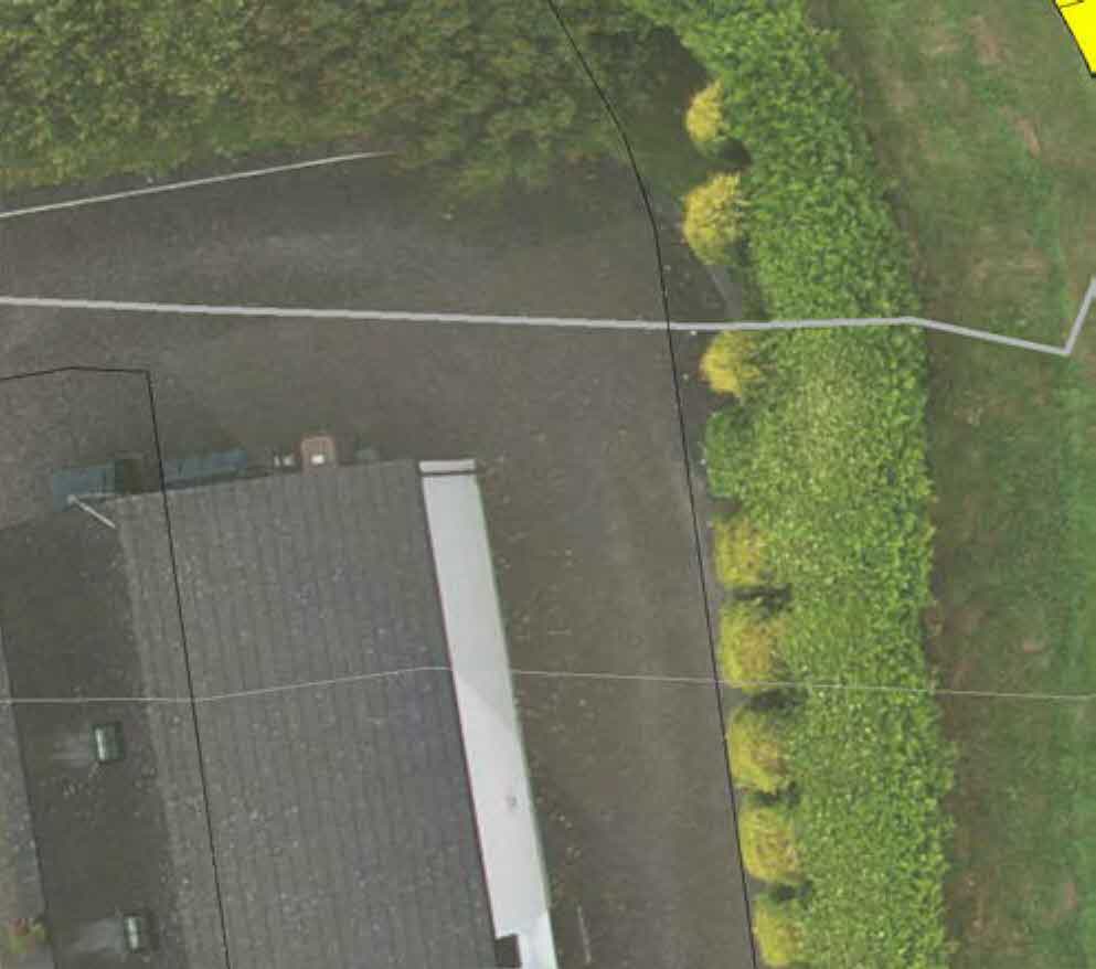 Aerial site plan showing a residential property with a proposed white extension or garage structure and boundary lines.