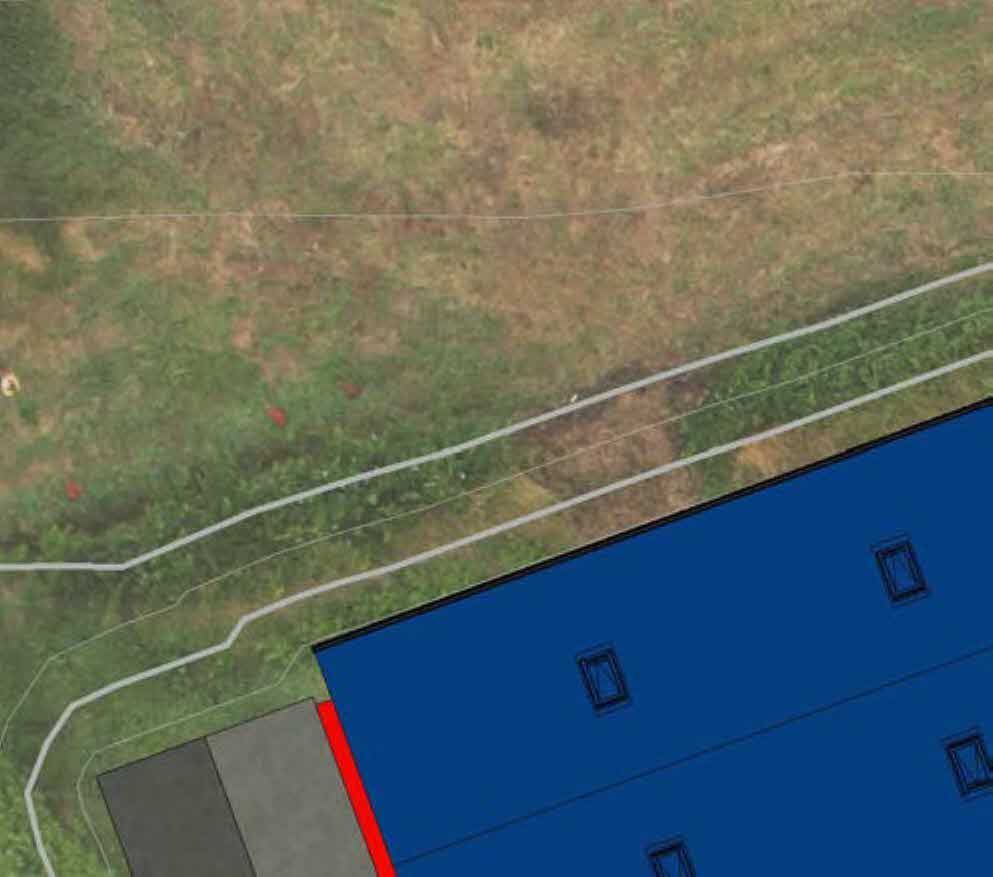 Aerial site plan showing a proposed blue extension footprint with windows, adjacent to existing grey structures and grassy land.
