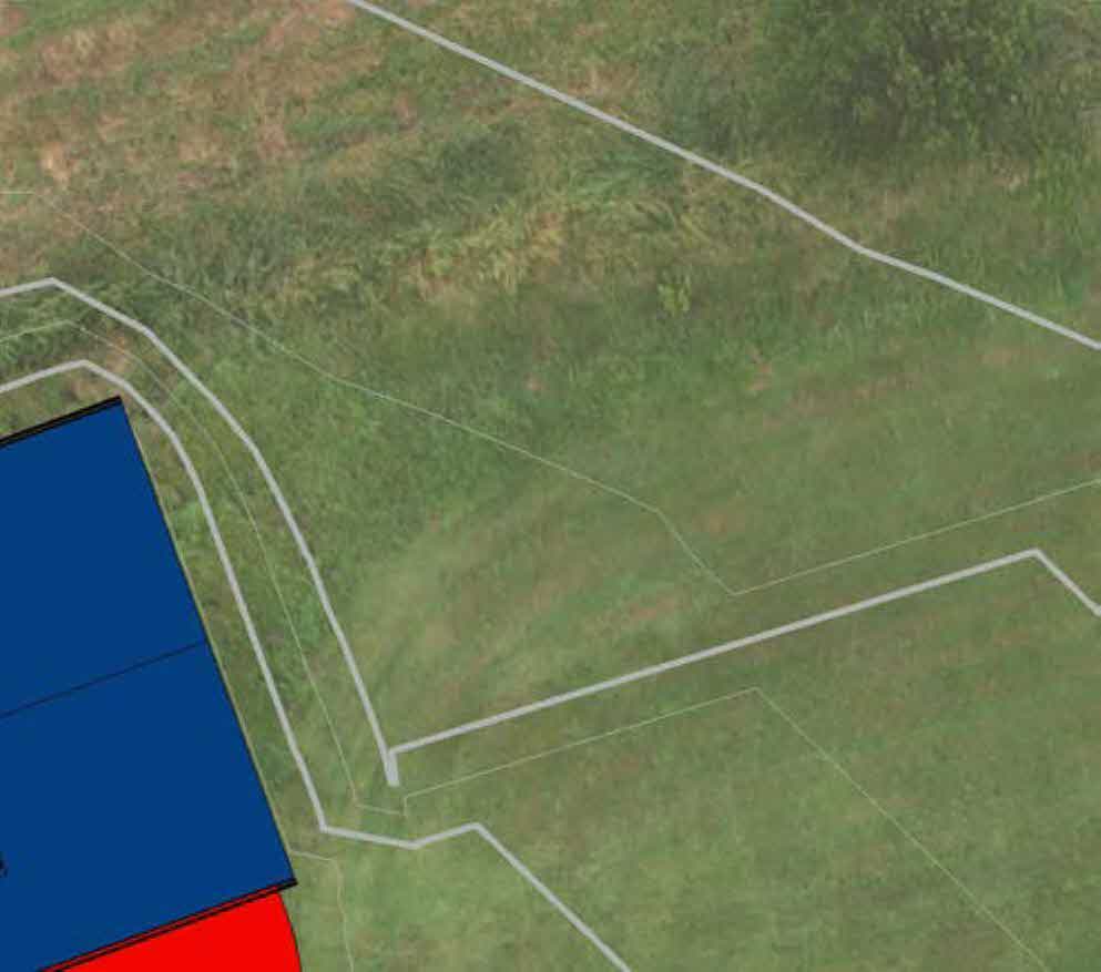 Aerial site plan showing property boundaries overlaid on a grassy field with a blue building footprint and a red proposed extension area.