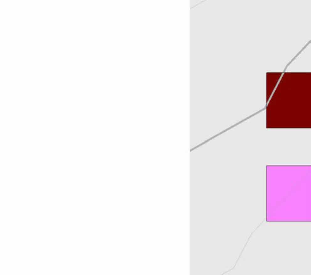 A cropped section of a site plan showing colored rectangular blocks representing building footprints and grey lines indicating roads or boundaries.