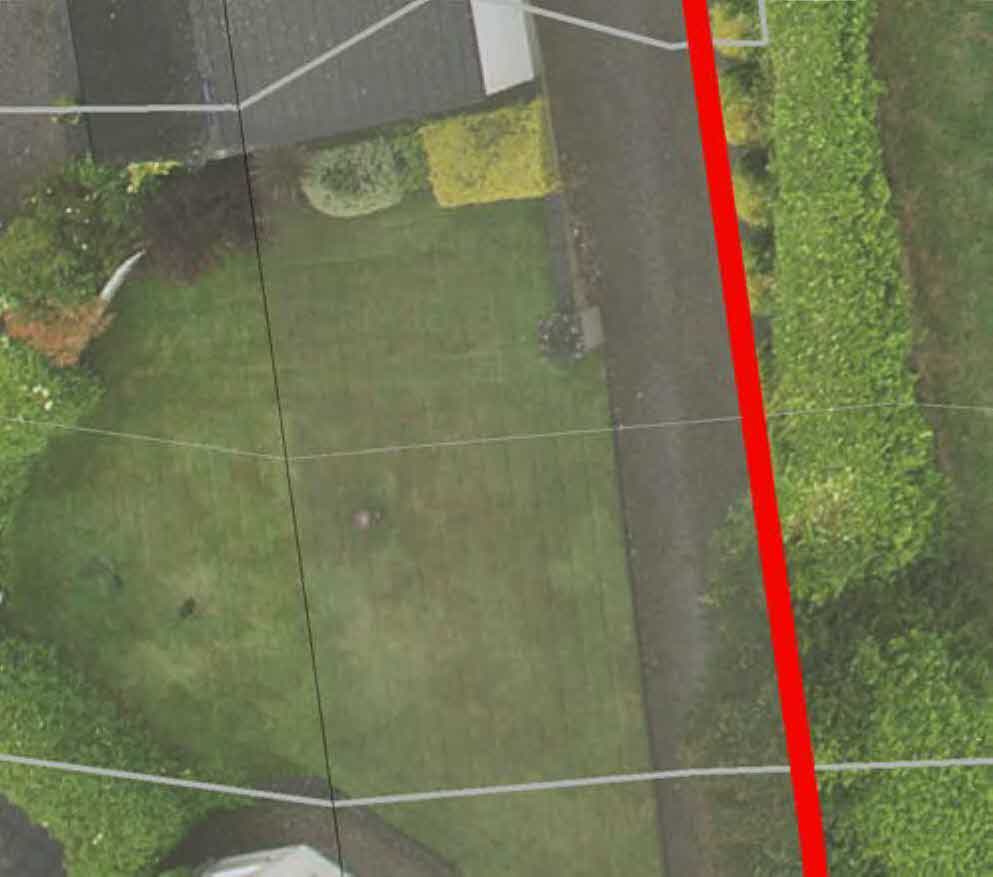 Aerial view of a residential property site showing a lawn, driveway, and hedges with white and red boundary lines overlaid.