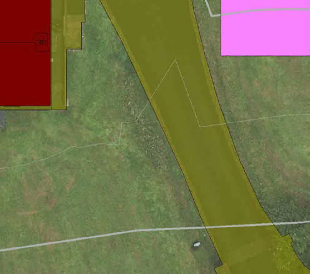 Aerial view of a rural property site with colored polygon overlays indicating property boundaries and zones.