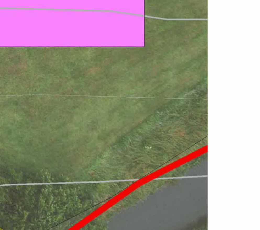 Aerial site plan showing a grassy field with a pink highlighted area and a red boundary line.