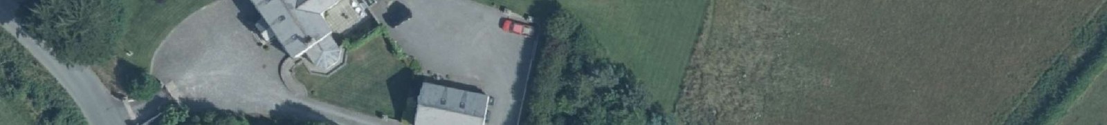 An aerial site plan showing a detached property with a large driveway, outbuildings, and surrounding agricultural fields.