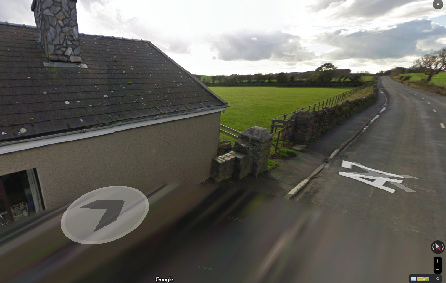 A Google Street View screenshot showing a detached house with a slate roof and stone chimney next to a rural road with a 40mph speed limit marking.