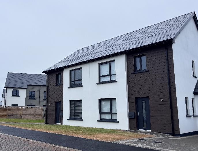 A photograph of a modern two-story residential property featuring white render and dark brown cladding with a grey tiled roof.