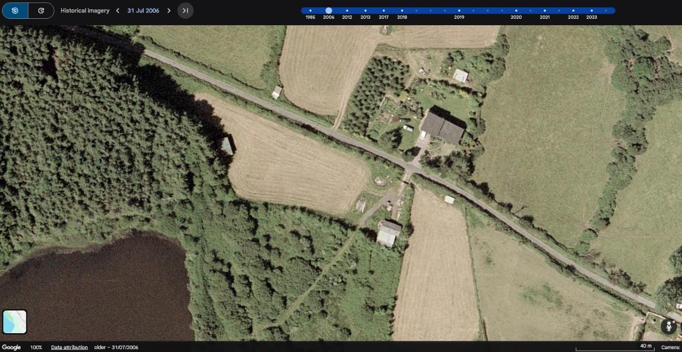 Historical aerial satellite imagery from July 2006 showing a rural road junction, agricultural fields, woodland, and scattered buildings.