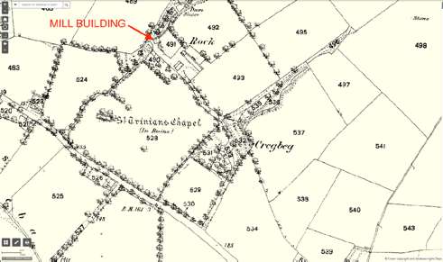 This image shows a historical map or site plan highlighting a 'MILL BUILDING' with a red arrow, surrounded by fields and landmarks like St. Trinians Chapel.