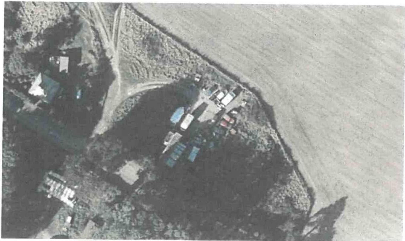 Aerial photograph showing a rural property with buildings, tracks, and adjacent agricultural fields.