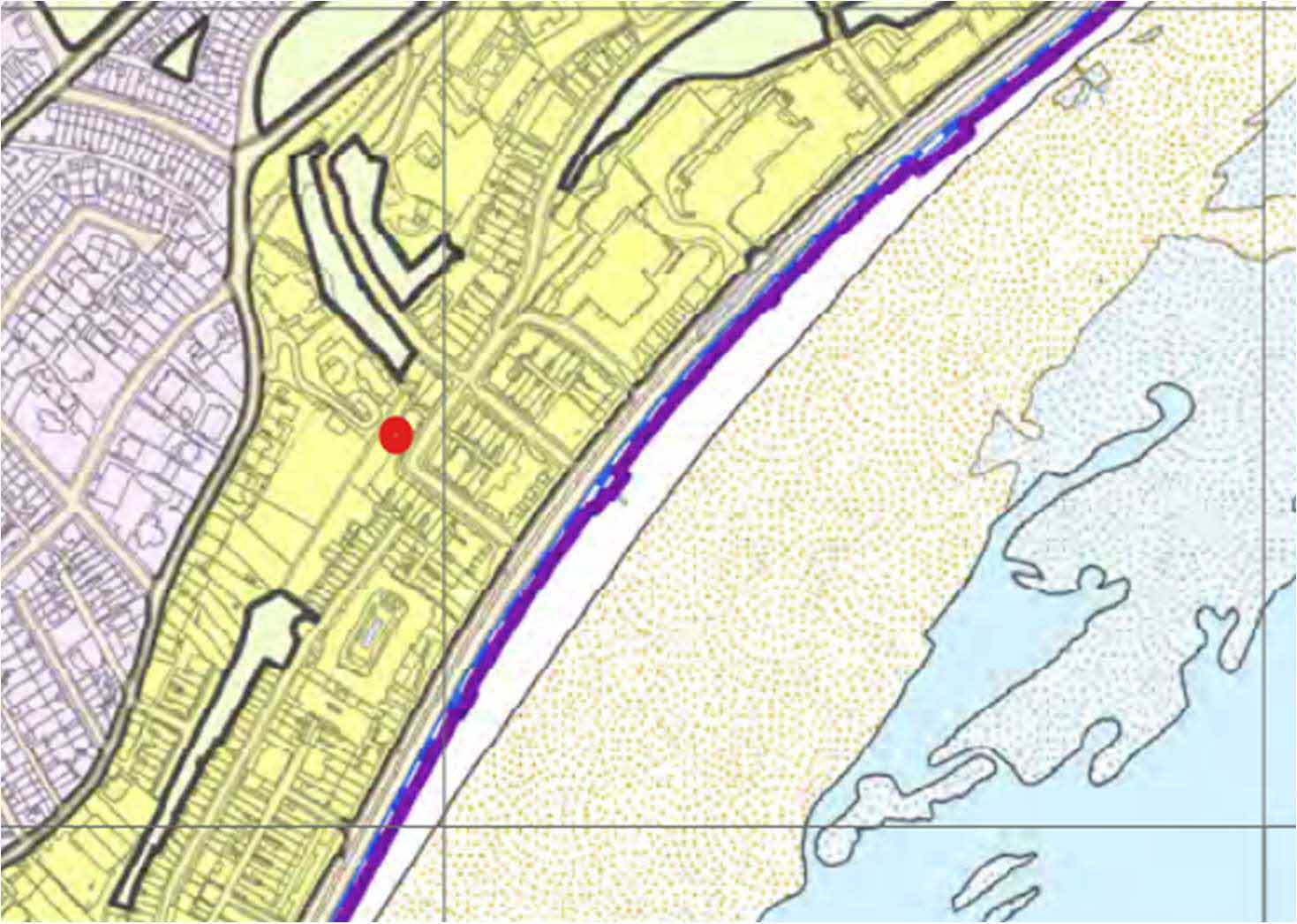 A planning site location map displaying zoning areas and a red dot indicating the specific application site near a coastline.