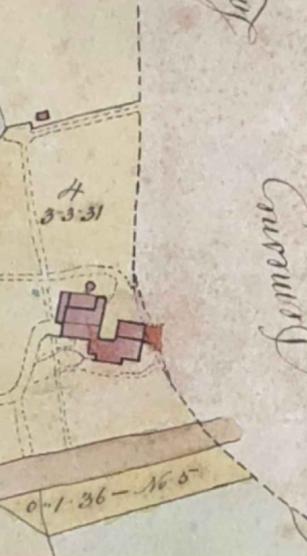 A close-up detail of a site plan showing a red building footprint, dashed property boundaries, and handwritten land measurements.