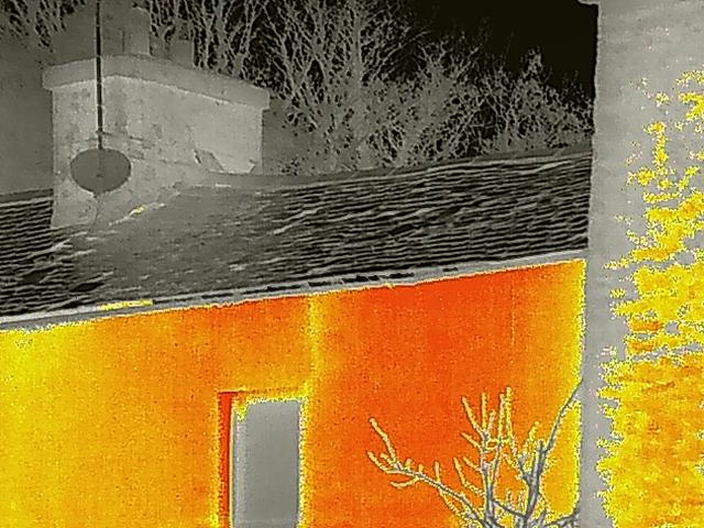 A false-color thermal photograph showing a stone chimney stack and tiled roof, likely used for a bat roost survey.