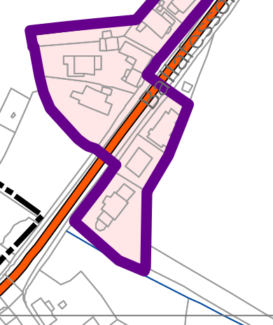 A site plan showing a property boundary outlined in purple and a road or railway line running diagonally through the site.