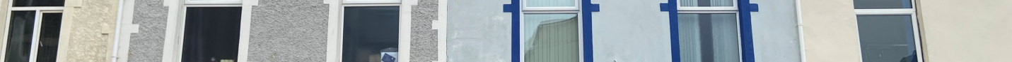 A panoramic photograph showing the ground floor facade of a building with roughcast walls and large windows marked with blue tape, consistent with shopfront refurbishment.
