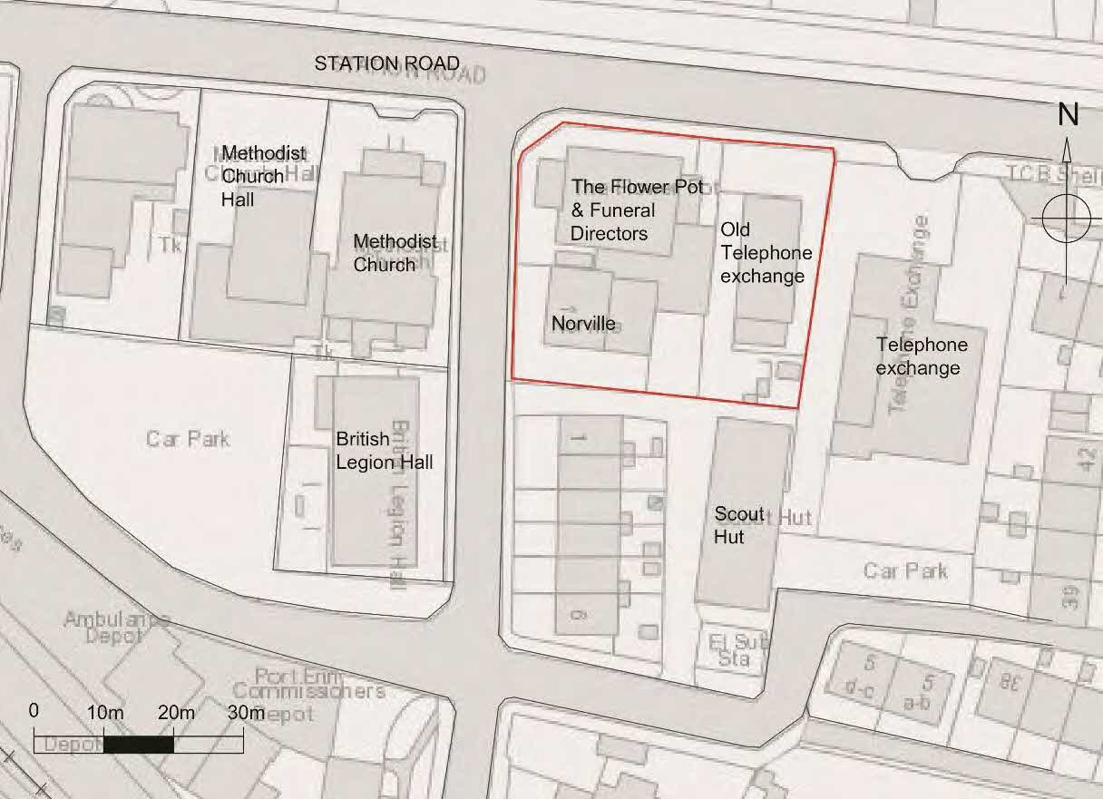 A black and white site plan showing building footprints and boundaries around Station Road, with a specific site highlighted in red.