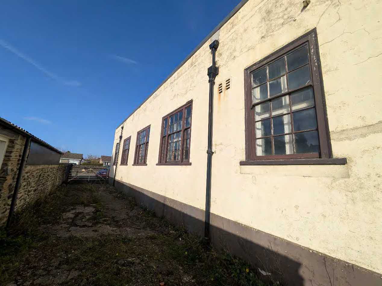A side elevation photograph of a long, single-story building with cream render and multiple sash windows, likely part of a historic building recording.