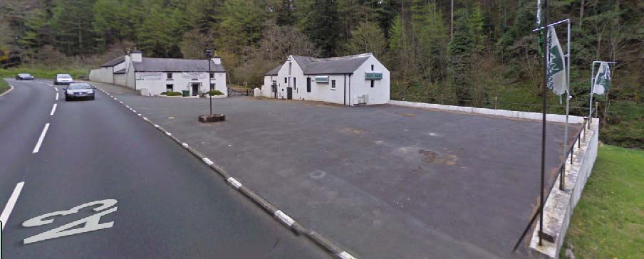 A panoramic photograph showing the A3 highway with a large paved forecourt and two white buildings set against a wooded background.